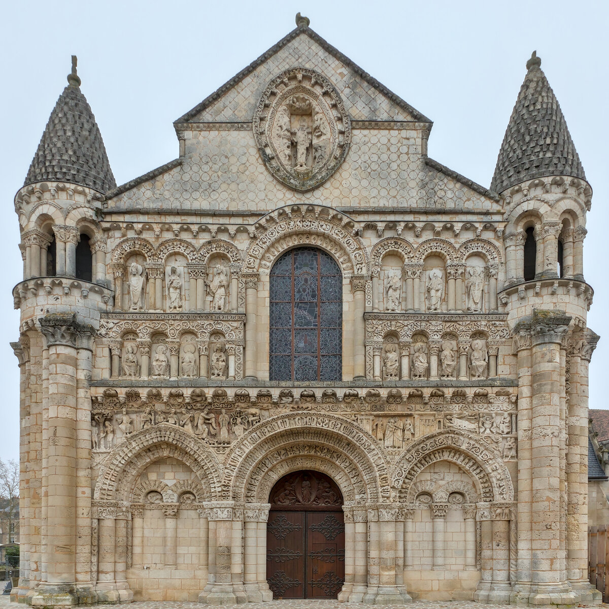 Façade romane de Notre-Dame-la-Grande à Poitiers, sculptée et arquée, dans la lumière d'après-midi